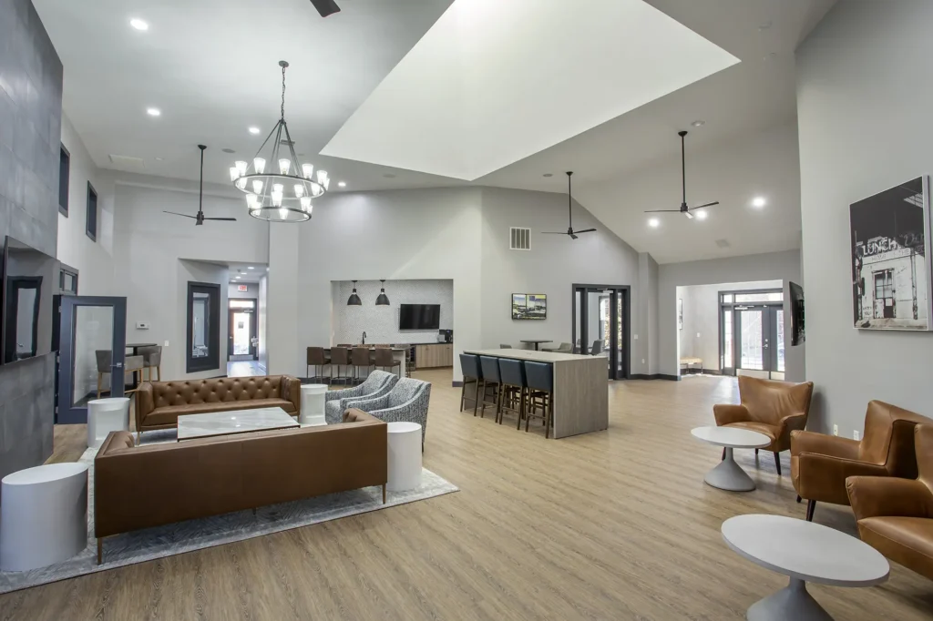 Clubhouse lounge with tables, chairs, sofas, and TVs