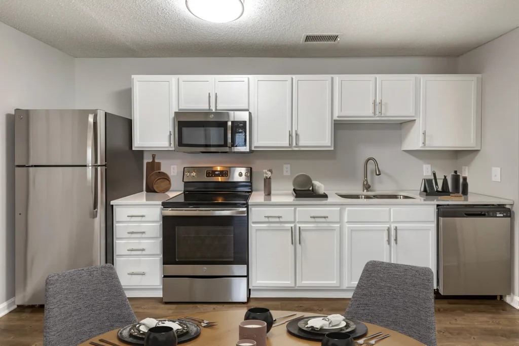 Open kitchen with white cabinets and counters and stainless steel appliances