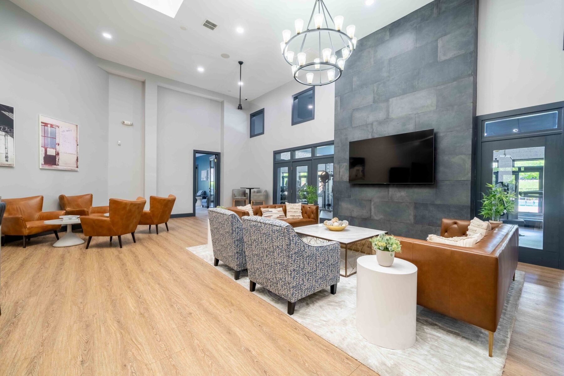 Clubhouse lounge with sofas, tables and armchairs around a TV