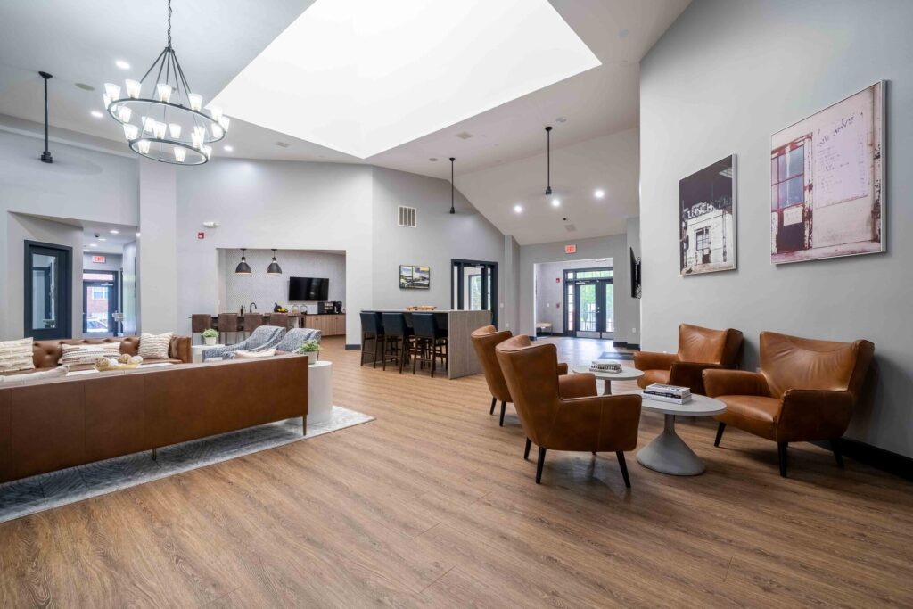 Clubhouse lounge with sofas, tables and armchairs around a TV