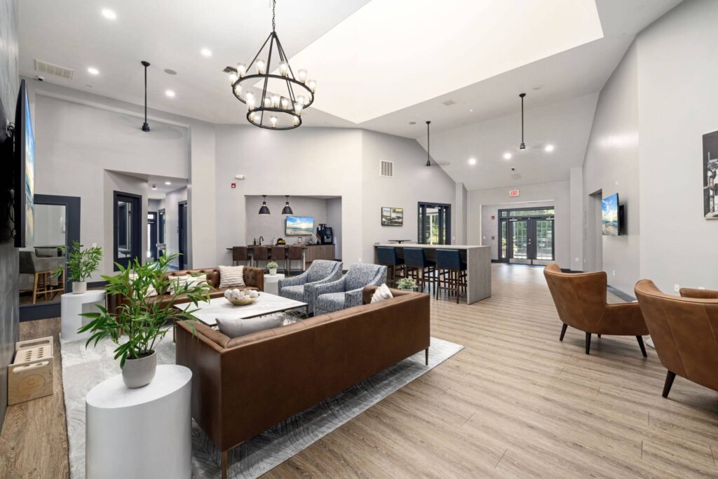 Clubhouse lounge with sofas, tables and armchairs around a TV